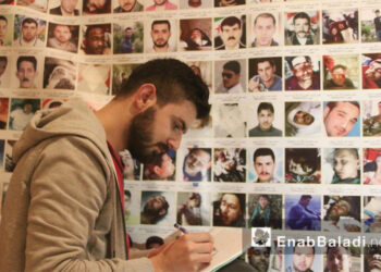 لاجئ سوري يستعد لعرض لوحة الـ”150 ألف شهيد”