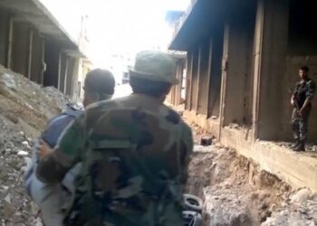 أمن النظام يسخر من سيدة مسنة: ابحثي عن ولدك في “حفرة التضامن”!