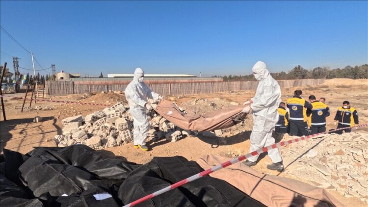 Teams work on the uncovered mass grave, believed to contain the remains of civilians killed by the ousted Assad regime, on the road to Damascus International Airport in the Syrian capital Damascus on December 16, 2024.